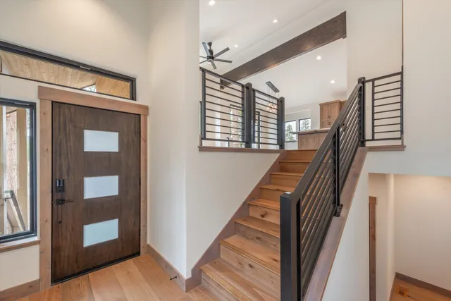 a view of a hallway with wooden floor and stairs