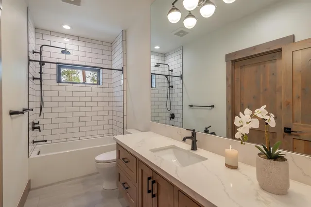 a bathroom with a granite countertop sink a toilet and shower