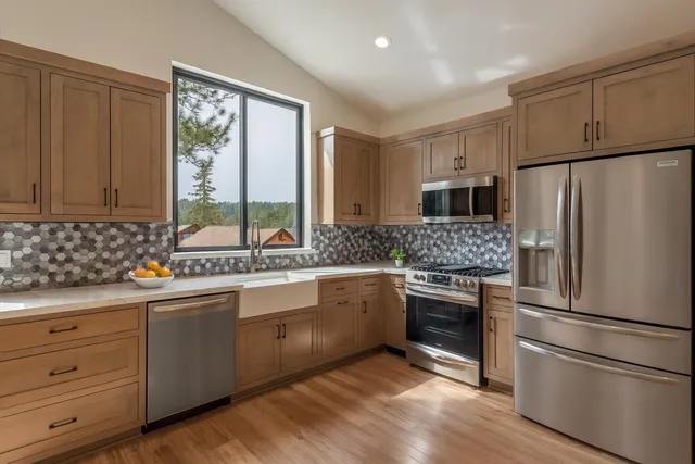 a kitchen with granite countertop stainless steel appliances a refrigerator sink and microwave