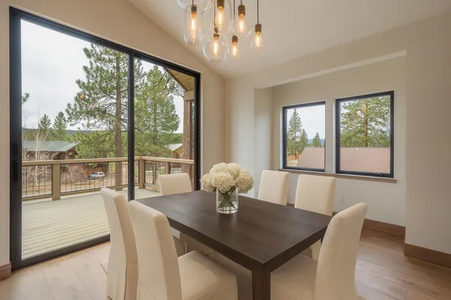 a view of a dining room with furniture large windows and wooden floor