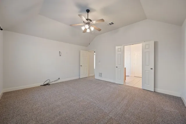 a view of an empty room with a chandelier fan