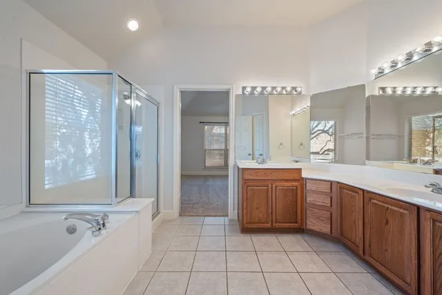 a spacious bathroom with a tub sink and mirror
