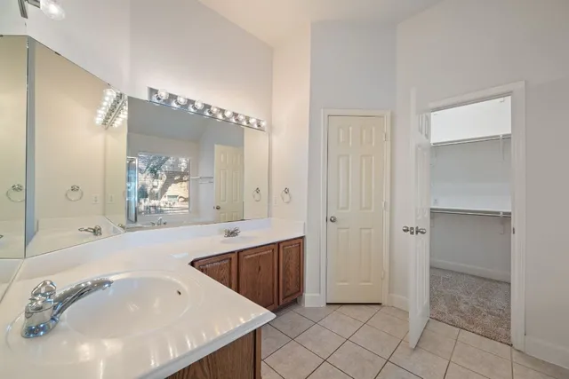 a spacious bathroom with a tub sink and mirror