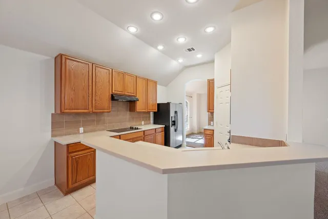 a kitchen with stainless steel appliances granite countertop a sink a stove and a refrigerator