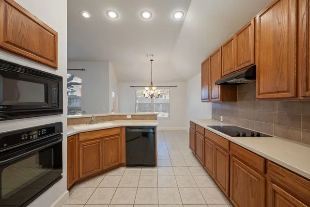 a kitchen with stainless steel appliances a stove sink microwave and cabinets