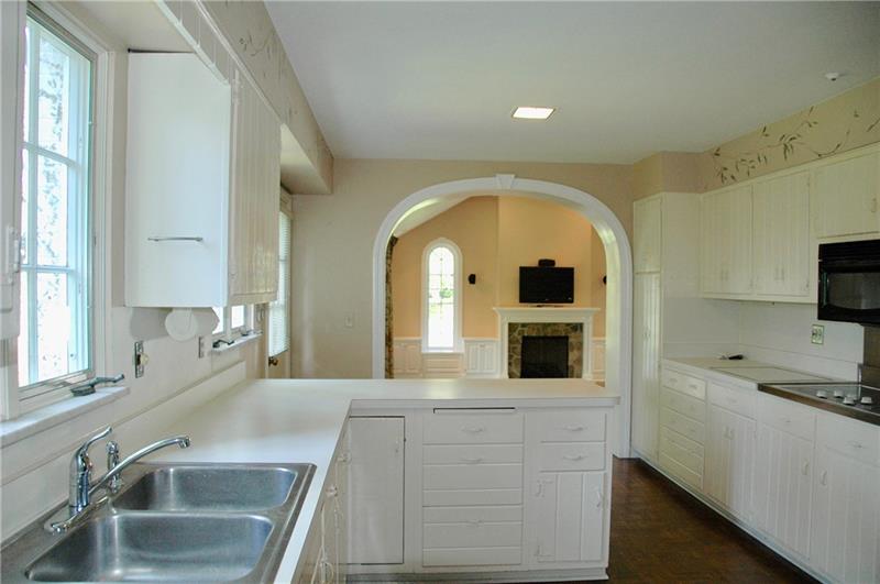 2 Farmhill Road Sewickley, PA 15143 - Photo 10 of 25 Kitchen has wide arched opening to Family Room, lots of cabinet storage and parquet flooring.