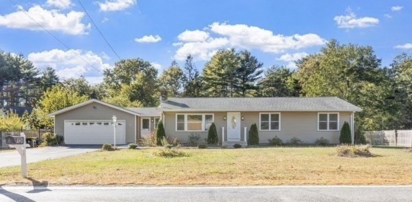 a front view of a house with a yard and trees
