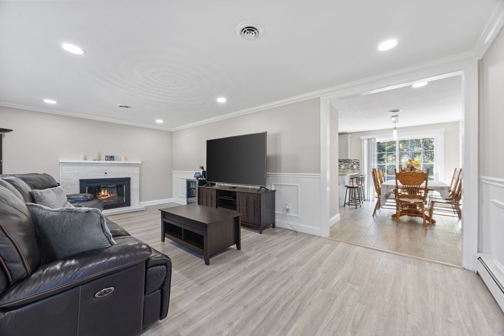 124 Lake Street Bellingham, MA 02019 - Photo 11 of 39 a living room with furniture a fireplace and a flat screen tv