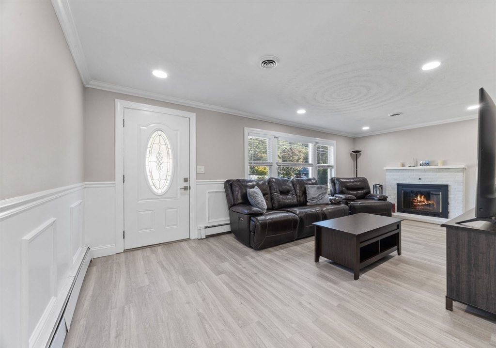 124 Lake Street Bellingham, MA 02019 - Photo 10 of 39 a living room with fireplace furniture and a wooden floor
