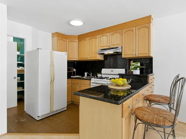 a kitchen with stainless steel appliances granite countertop a refrigerator a stove a sink and a counter