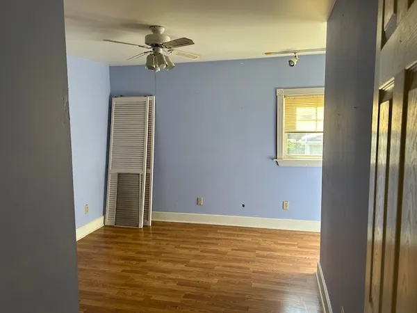 a view of a room with a ceiling fan and a window