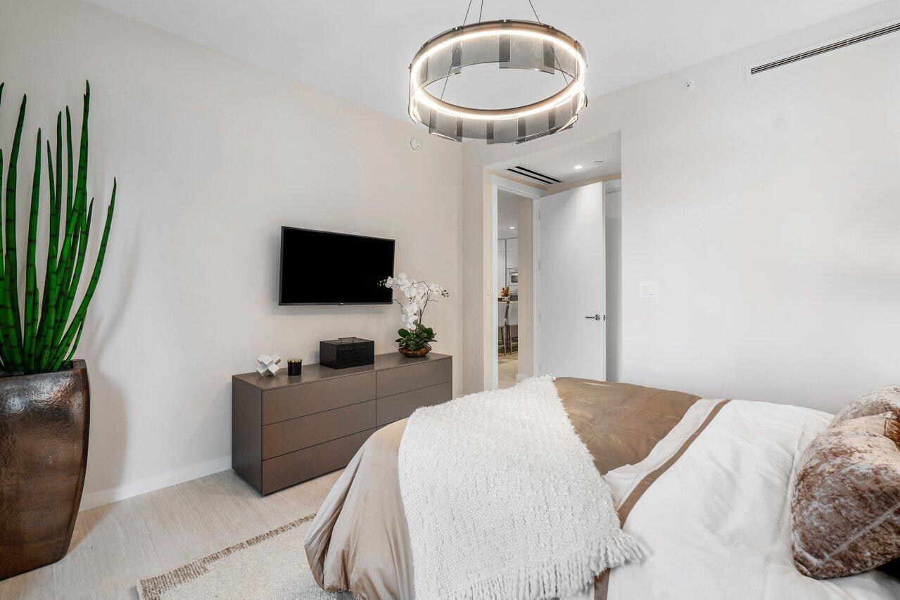 200 Southeast Mizner Boulevard, Unit 211 Boca Raton, FL 33432 - Photo 23 of 67 a bedroom with a bed and a flat screen tv