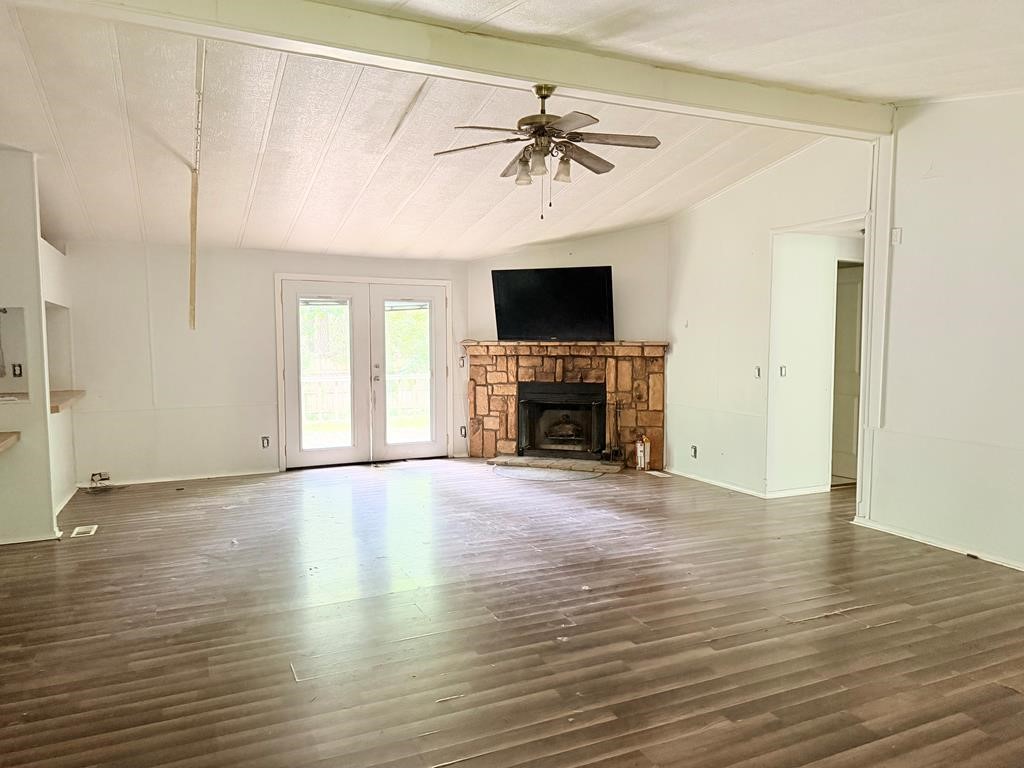 86 Whippoorwill Lane Trinity, TX 75862 - Photo 35 of 47 an empty room with wooden floor fireplace and windows