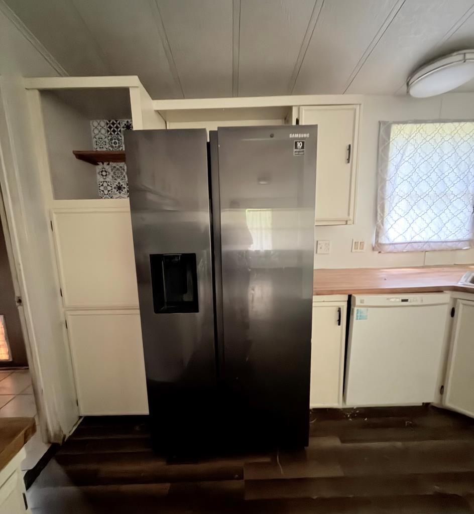 86 Whippoorwill Lane Trinity, TX 75862 - Photo 40 of 47 a view of a refrigerator in kitchen and an empty room with wooden floor