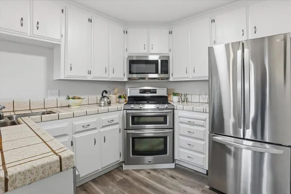 a kitchen with cabinets stainless steel appliances and a counter space