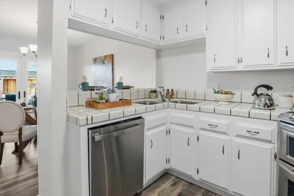 a kitchen with white cabinets and sink