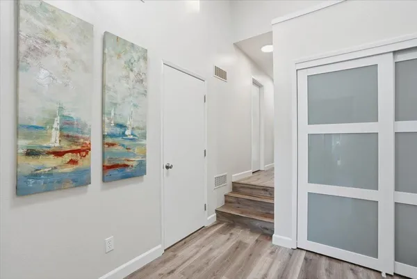 a view of a hallway with wooden floor and entryway