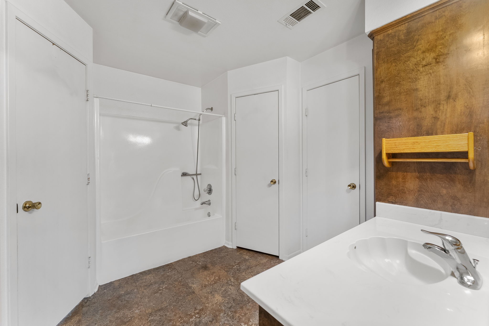 202 Sunset Boulevard Conroe, TX 77303 - Photo 32 of 50 Discover a spacious primary bathroom featuring a pristine shower-tub combo, sleek vanity with modern fixtures, and ample storage, all set against an inviting warm-toned backdrop.