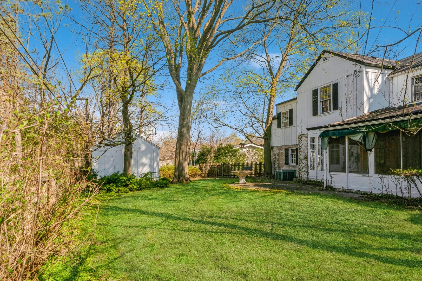 872 Green Bay Road Highland Park, IL 60035 - Photo 23 of 30 a view of a white house with a big yard and potted plants and large trees