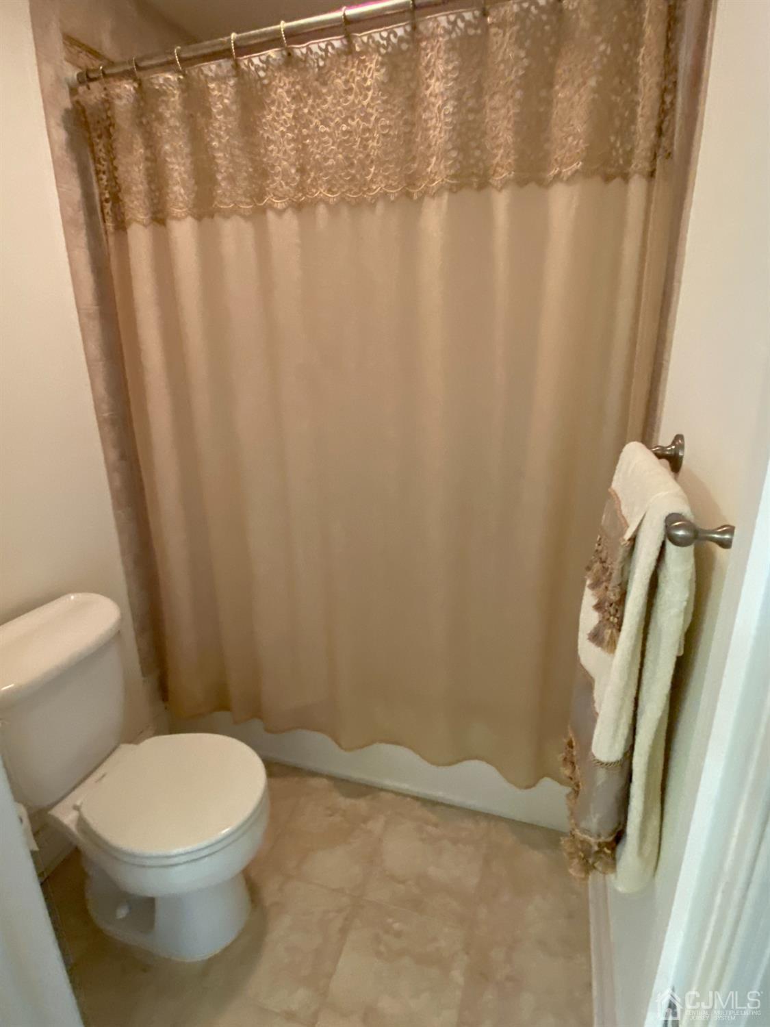 418 Cliff Road Sewaren, NJ 07077 - Photo 48 of 63 a white toilet sitting next to a shower curtain