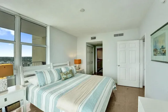 a bedroom with bed and a large window