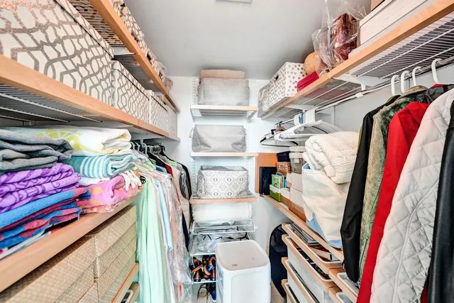 a view of walk in closet with clothes and shoes