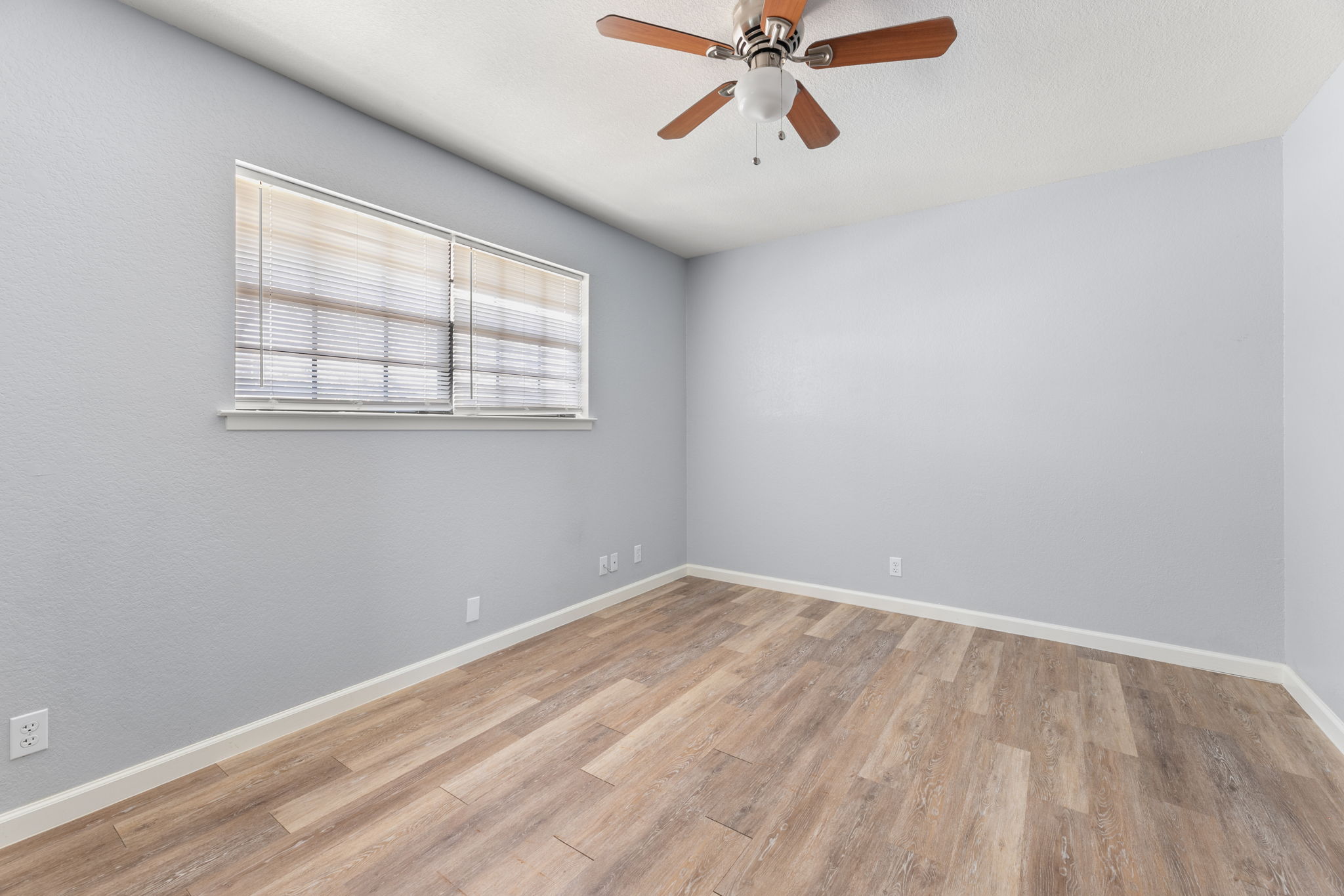 3802 Foust Trail, Unit A Georgetown, TX 78628 - Photo 21 of 34 A comfortable bedroom with rich wood-look flooring and a functional ceiling fan awaits its next resident.