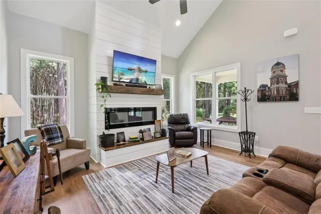 a living room with furniture a flat screen tv and a fireplace