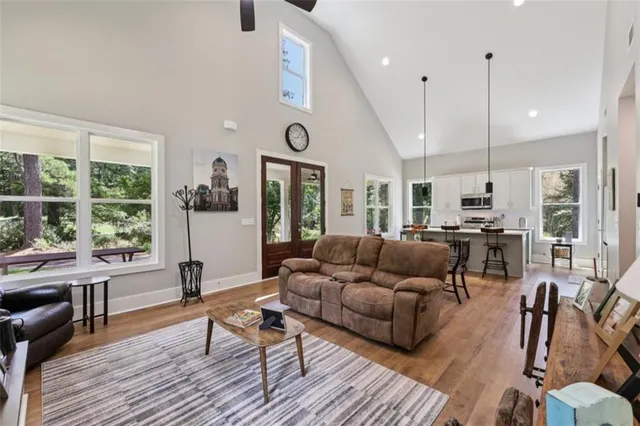 a living room with furniture kitchen view and a wooden floor