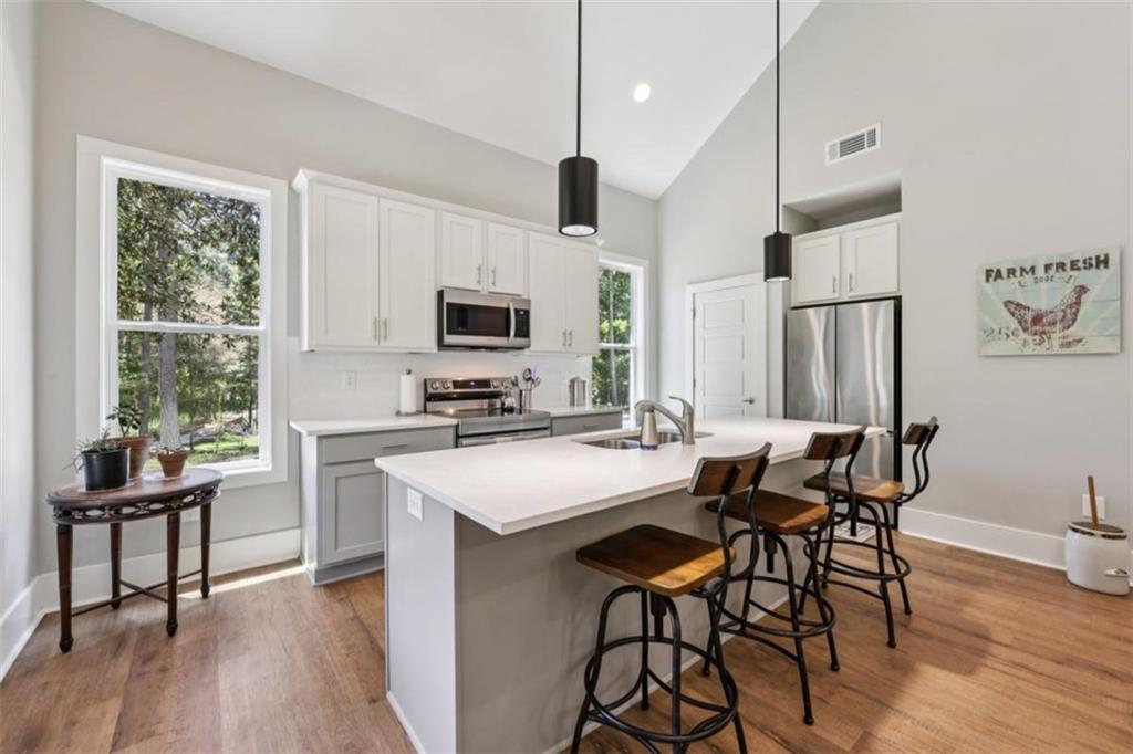 250 Stagecoach Road Oxford, GA 30054 - Photo 23 of 76 a kitchen with a table chairs refrigerator and microwave