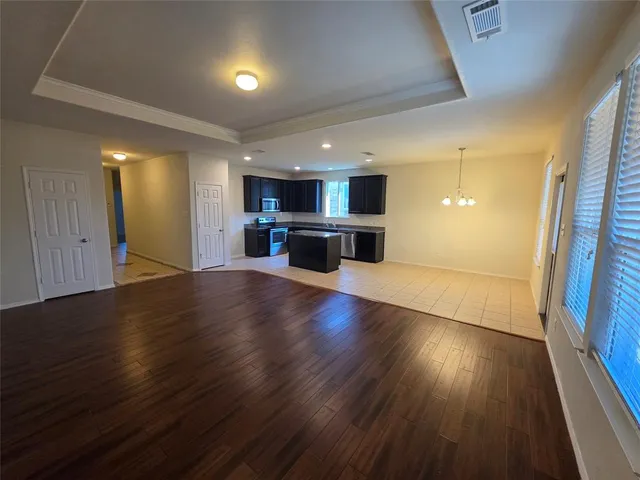 an empty room with a wooden floor and window
