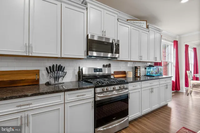 a kitchen with stainless steel appliances granite countertop a refrigerator and a stove top oven