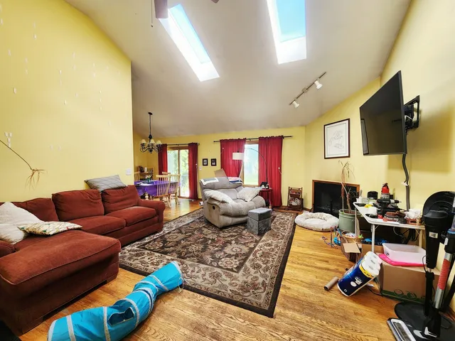 a living room with furniture kitchen view and a flat screen tv