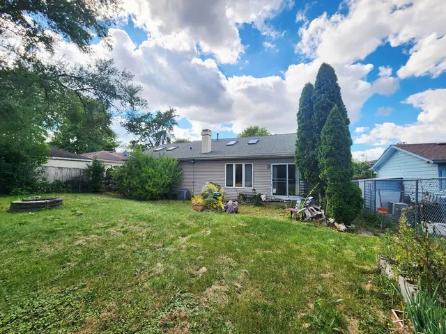 a view of a house with backyard sitting area and garden