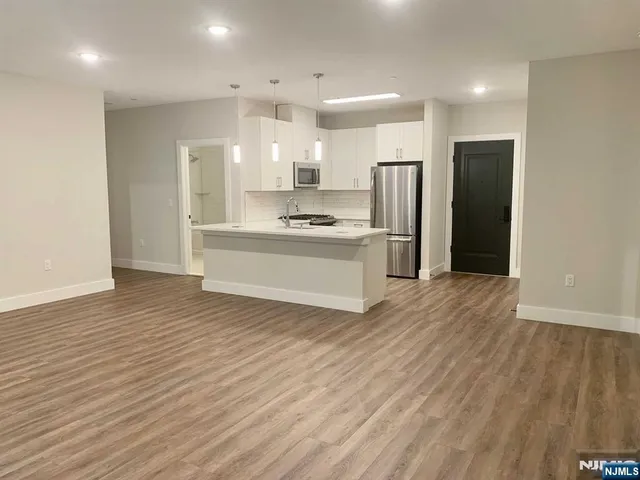 a large kitchen with stainless steel appliances a refrigerator and a stove top oven