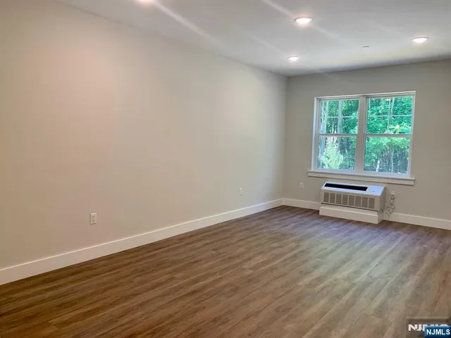 a view of a room with wooden floor and window
