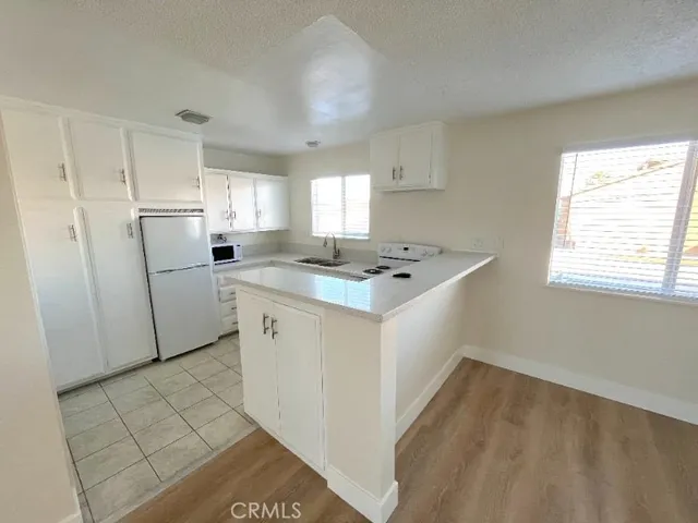 a kitchen with cabinets appliances a sink and a window
