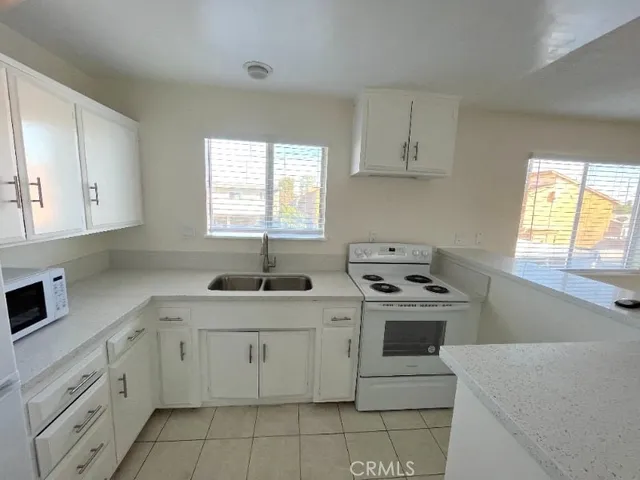 a kitchen with white cabinets and white appliances
