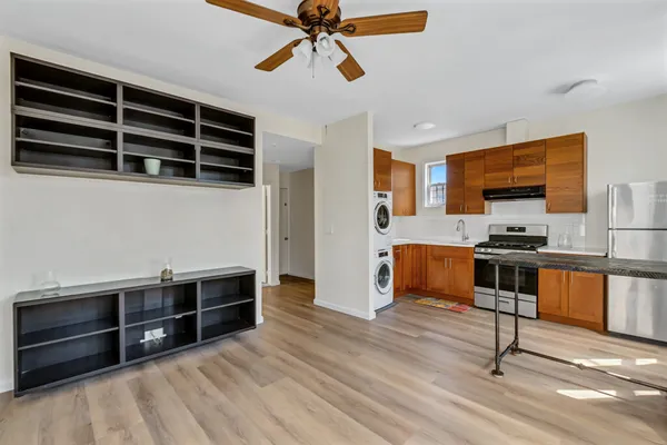 a kitchen with stainless steel appliances wooden floor and a refrigerator