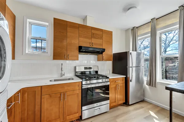 a kitchen with stainless steel appliances a stove a refrigerator and a sink