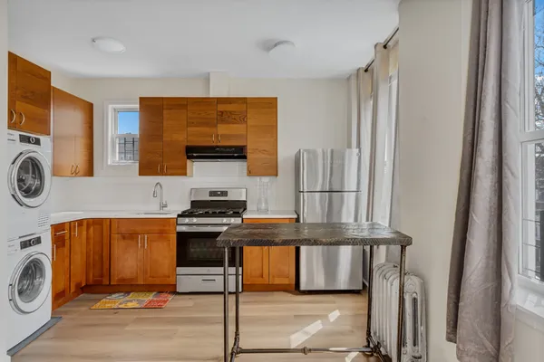 a view of a kitchen with stainless steel appliances granite countertop a stove and a refrigerator