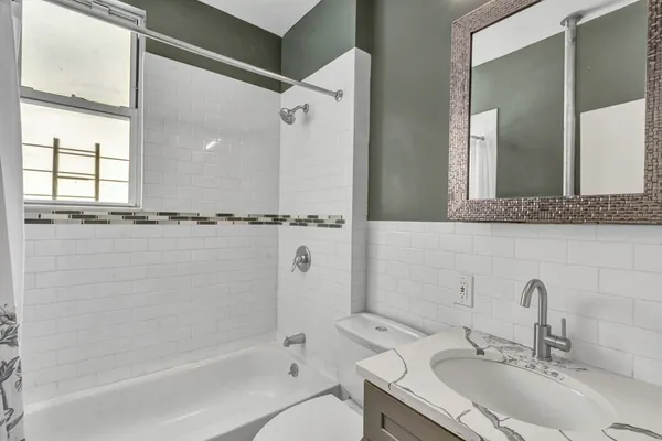a bathroom with a sink and mirror with bathtub