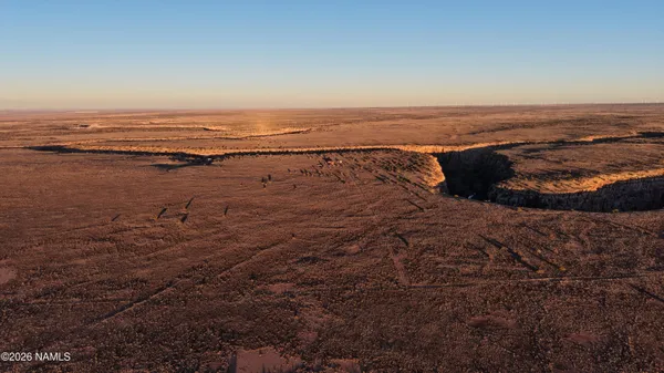 an aerial view of house with yard and mountain view in back