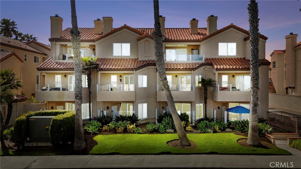 2000 Pacific Coast Highway, Unit 102 Huntington Beach, CA 92648 - Photo 1 of 35 a front view of a residential apartment building with a yard