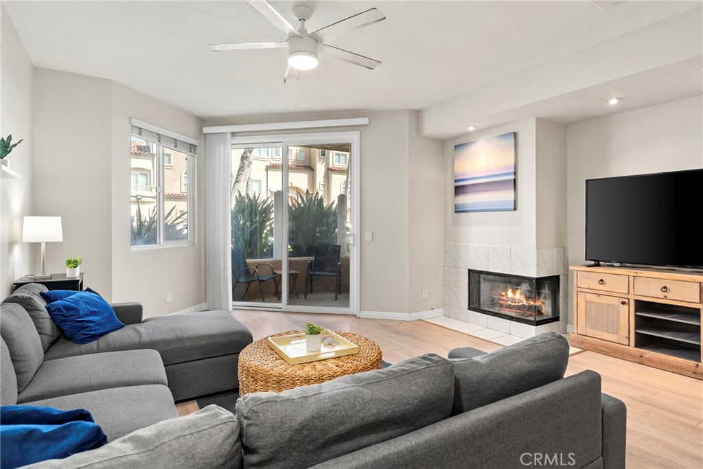 2000 Pacific Coast Highway, Unit 102 Huntington Beach, CA 92648 - Photo 8 of 35 a living room with furniture a fireplace and a flat screen tv