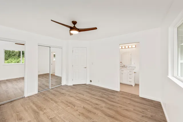 a view of empty room with wooden floor and window