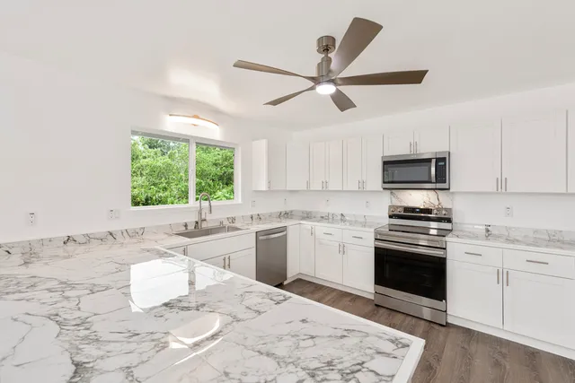 a kitchen with a stove a sink and a microwave