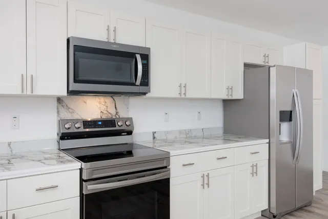 a kitchen with appliances a sink and cabinets
