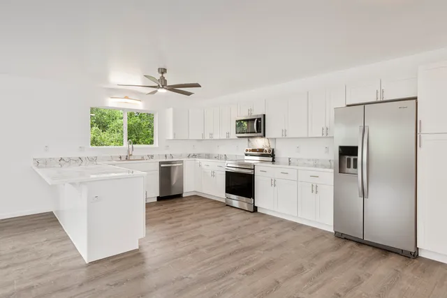 a kitchen with white cabinets and white appliances