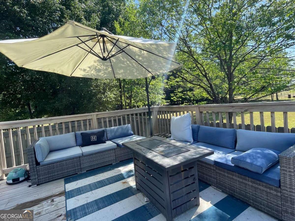 457 Old Good Hope Road Good Hope, GA 30641 - Photo 37 of 59 a roof deck with a table and chairs under an umbrella